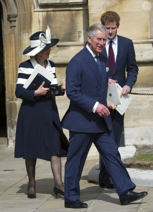 Le prince Harry avec son père le prince Charles et sa belle-mère Camilla Parker Bowles à la sortie de la chapelle Saint-George. Jour de commémoration à Windsor : le 30 mars 2012 au matin, les royaux britanniques se remémoraient, à l'initiative de la reine Elizabeth II, les regrettées reine mère et princesse Margaret, respectivement décédées à 101 et 71 ans en 2002.