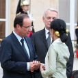 Le président François Hollande et le premier ministre Jean-Marc Ayrault saluent Aung San Suu Kyi à l'Elysée pour un dîner donné en son honneur, le 26 juin 2012.