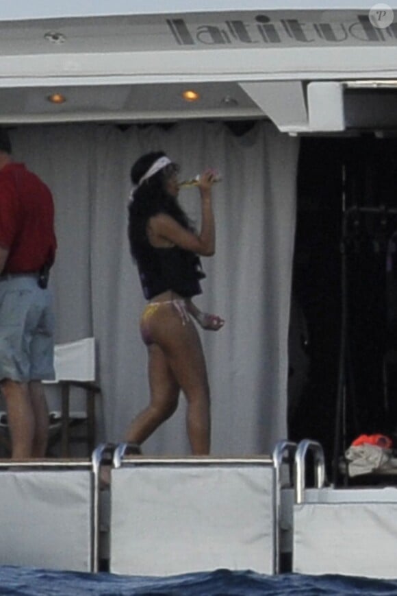 Rihanna, prête à grimper sur sa bouée, sirote une bière. Capri, le 18 juillet 2012.