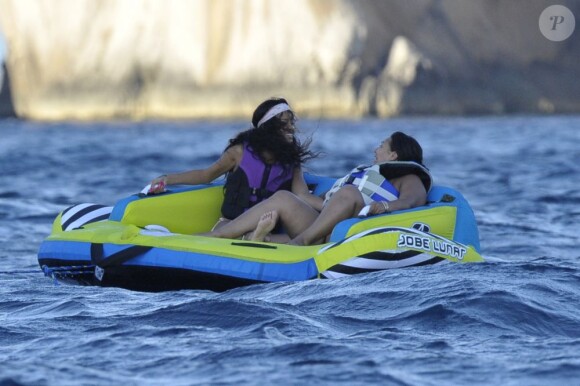 Rihanna et son amie, déchaînées durant leur course sur une bouée tractée. Capri, le 18 juillet 2012.