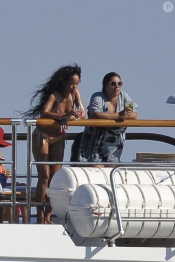 Rihanna et son amie, cocktails en main, se détendent sur leur yacht à Capri, le 18 juillet 2012.