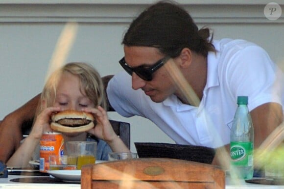 Zlatan Ibrahimovic observe son fils Maximilian déguster un bon burger le 15 juillet sur l'île de Formentera
