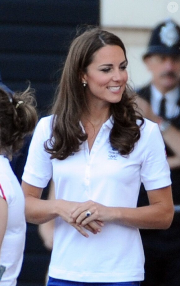 Kate Middleton, le prince William et le prince Harry, vêtus du T-Shirt officiel de la délégation olympique britannique, ont assisté au passage du relais de la flamme olympique à Buckingham Palace, le 26 juillet 2012, à l'avant-dernier jour du périple. Ils ont applaudi le relais entre Wai-Ming et John Hulse.