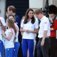  Kate Middleton, le prince William et le prince Harry, vêtus du T-Shirt officiel de la délégation olympique britannique, ont assisté au passage du relais de la flamme olympique à Buckingham Palace, le 26 juillet 2012, à l'avant-dernier jour du périple. Ils ont applaudi le relais entre Wai-Ming et John Hulse. 