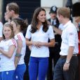  Kate Middleton, le prince William et le prince Harry, vêtus du T-Shirt officiel de la délégation olympique britannique, ont assisté au passage du relais de la flamme olympique à Buckingham Palace, le 26 juillet 2012, à l'avant-dernier jour du périple. Ils ont applaudi le relais entre Wai-Ming et John Hulse. 
