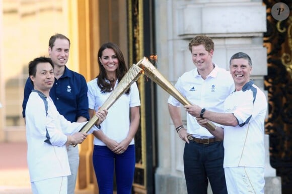 Le duc et la duchesse de Cambridge et le prince Harry, vêtus du T-Shirt officiel de la délégation olympique britannique, ont assisté au passage du relais de la flamme olympique à Buckingham Palace, le 26 juillet 2012, à l'avant-dernier jour du périple. Ils ont applaudi le relais entre Wai-Ming et John Hulse.