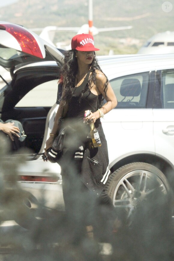 Avec une bière à la main, Rihanna arrive à l'aéroport en Sardaigne le 15 juillet 2012