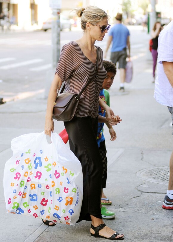 Heidi Klum, portant un sac Toys"R"Us à la main, est surprise avec ses enfants dans le quartier de SoHo. New York, le 6 août 2012.