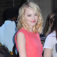 Emma Stone, craquante dans une petite robe corail, arrive au défilé Calvin Klein printemps-été 2013. New York, le 13 septembre 2012.