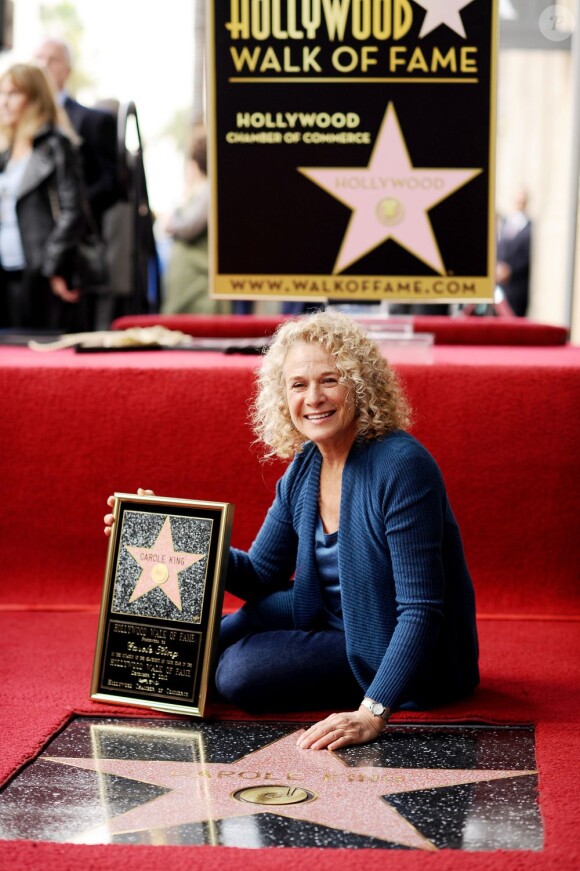 Carole King assise à côté de son étoile sur le Hollywood Walk of Fame à Los Angeles, le 3 décembre 2012.