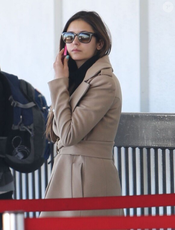 Nina Dobrev et Ian Somerhalder à l'aéroport de Los Angeles, le 26 décembre 2012. L'actrice passe un dernier coup de téléphone avant de s'envoler pour la Chine.