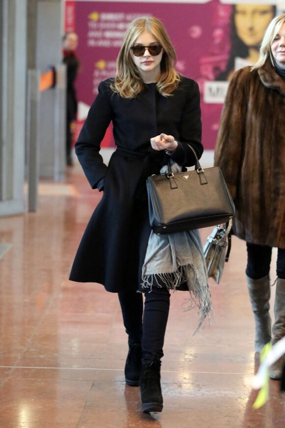 Chloë Moretz, tout de noir vêtue avec un sac Prada au bras, arrive à l'aéroport de Roissy Charles de Gaulle. Le 18 janvier 2013.