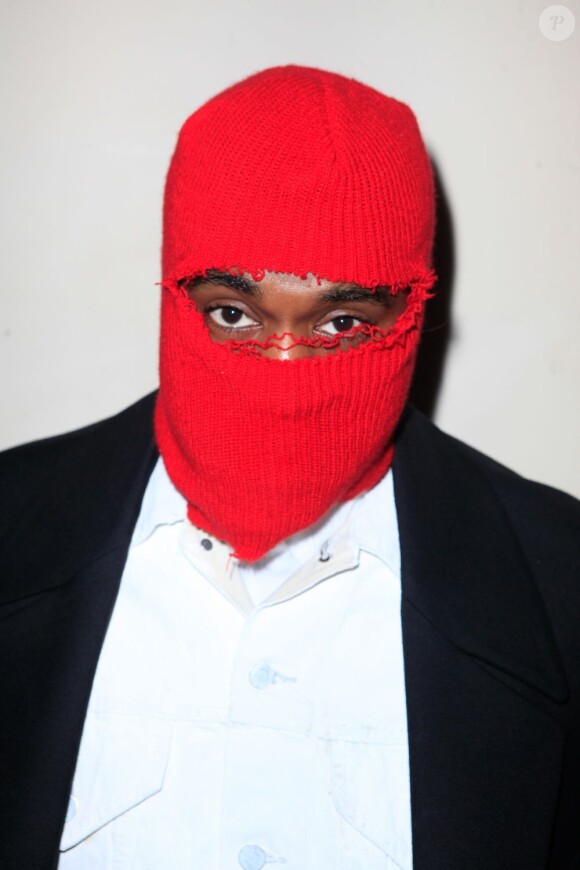 Kanye West, masqué grâce à une cagoule rouge, assiste au défilé haute couture Maison Martin Margiela printemps-été 2013 à Paris. Le 23 janvier 2013.