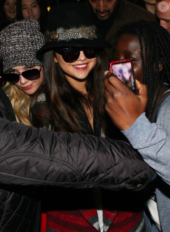 Selena Gomez tout sourire suivi d'Ashley Benson à l'aéroport de Roissy Charles-de-Gaulle pour le film Spring Breakers, le 16 février 2013.