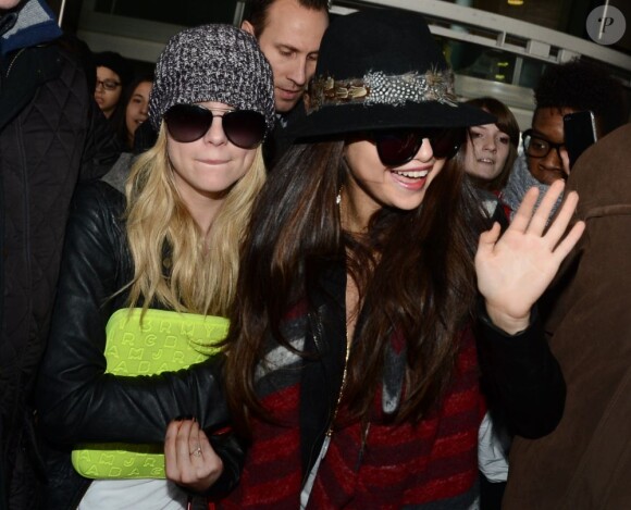 Selena Gomez salue ses fans en tenant la main d'Ashley Benson, à l'aéroport de Roissy, le 16 février 2013.