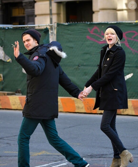 Andrew Garfield salue pendant qu'Emma Stone interpelle dans les rues de New York le 28 février 2013.