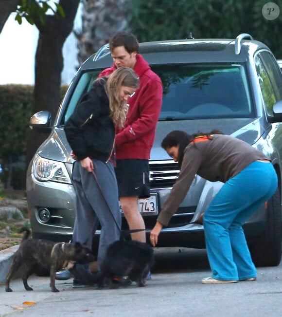 En tenue de sport, Michael C. Hall, acteur principal de la série Dexter, et sa compagne Morgan Macgregor promènent leur chien dans les rues de Los Angeles. Le 3 mars 2013.