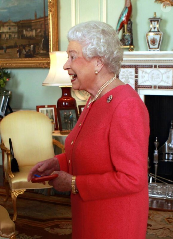 La reine Elizabeth II, très heureuse, remet la Queen's Gold Medal au poète John Agard au Palais de Buckingham à Londres, le 12 mars 2013.