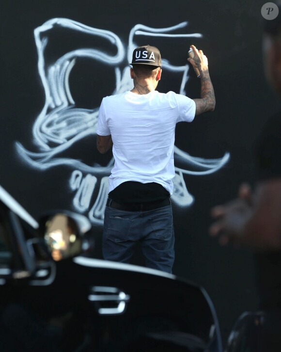 Chris Brown fait des graffitis pour une oeuvre de charité sur un mur à Miami, le 26 mars 2013.