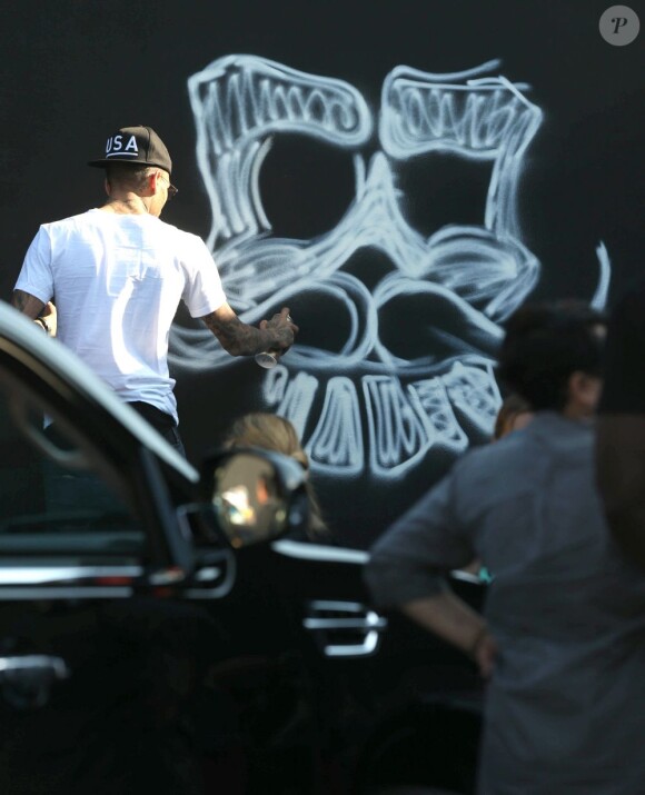 Chris Brown fait des graffitis pour une oeuvre de charité sur un mur à Miami, le 26 mars 2013.