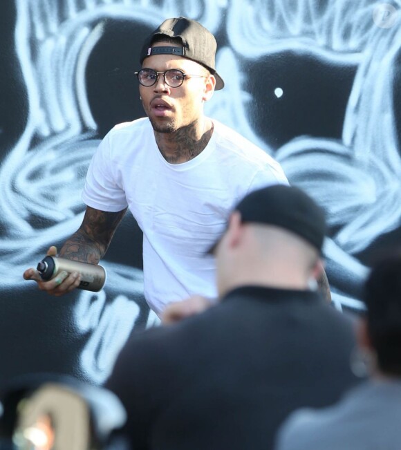Chris Brown fait des graffitis pour une oeuvre de charité sur un mur à Miami, le 26 mars 2013.