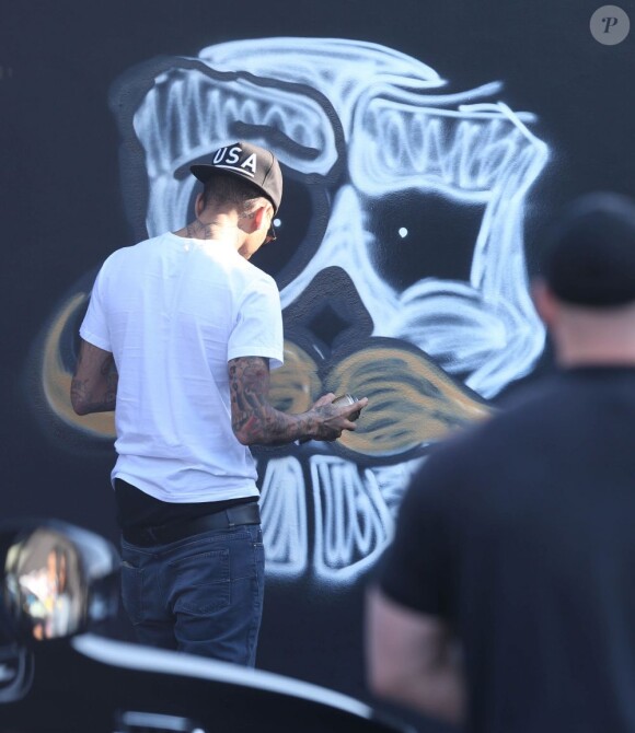 Chris Brown fait des graffitis pour une oeuvre de charité sur un mur à Miami, le 26 mars 2013.