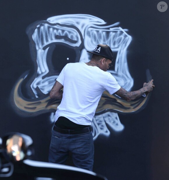 Chris Brown fait des graffitis pour une oeuvre de charité sur un mur à Miami, le 26 mars 2013.