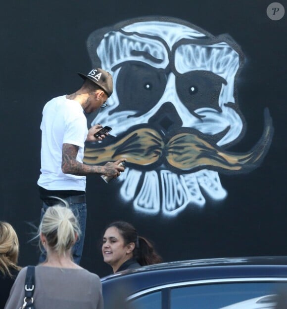 Chris Brown fait des graffitis pour une oeuvre de charité sur un mur à Miami, le 26 mars 2013.
