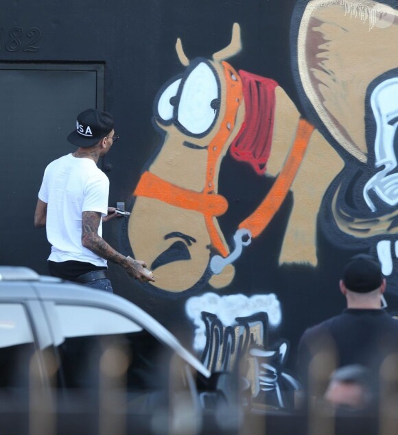 Chris Brown fait des graffitis pour une oeuvre de charité sur un mur à Miami, le 26 mars 2013.