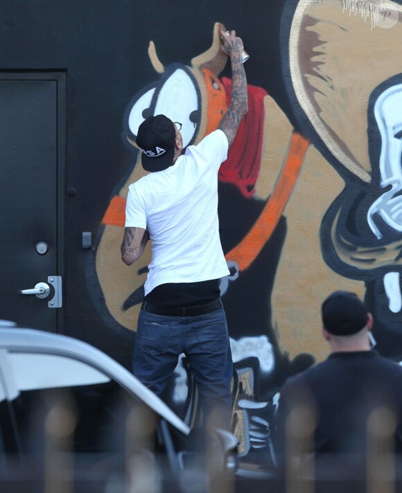 Chris Brown fait des graffitis pour une oeuvre de charité sur un mur à Miami, le 26 mars 2013.