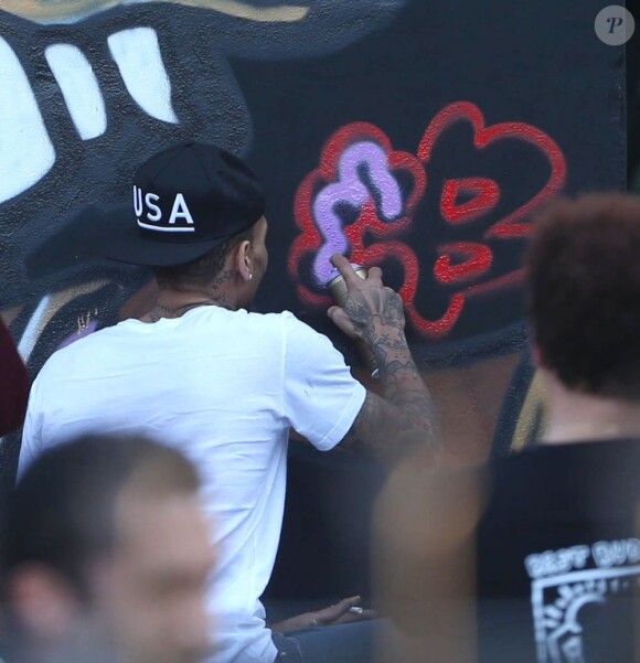 Chris Brown fait des graffitis pour une oeuvre de charité sur un mur à Miami, le 26 mars 2013.