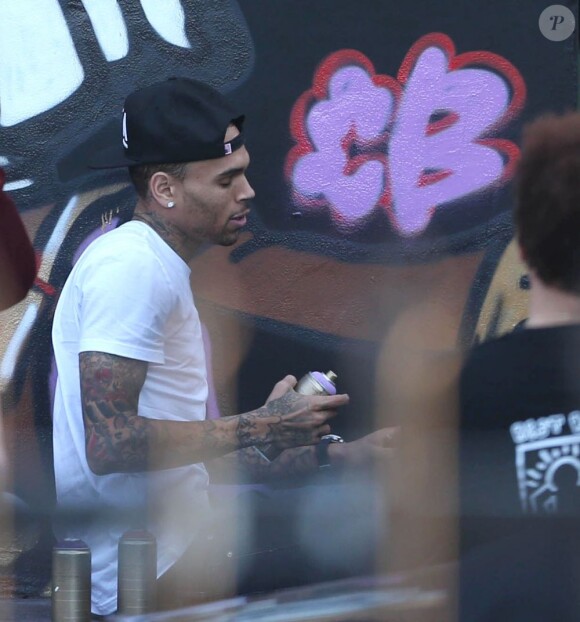 Chris Brown fait des graffitis pour une oeuvre de charité sur un mur à Miami, le 26 mars 2013.
