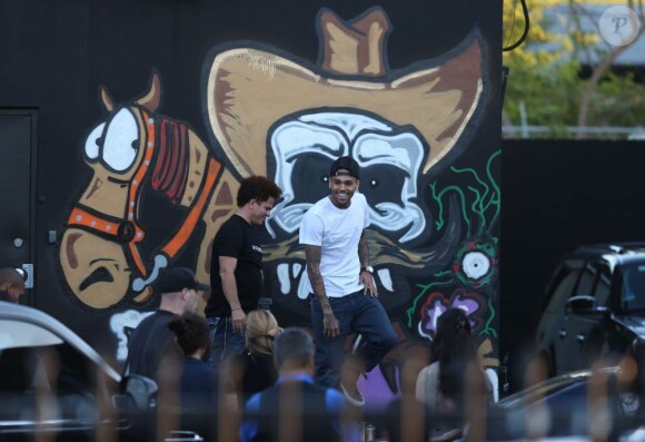 Chris Brown fait des graffitis pour une oeuvre de charité sur un mur à Miami, le 26 mars 2013.