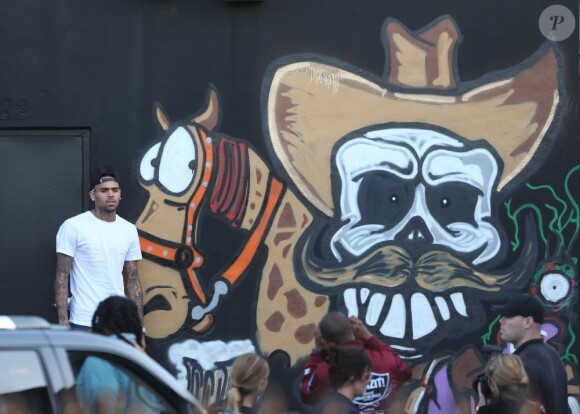 Chris Brown fait des graffitis pour une oeuvre de charité sur un mur à Miami, le 26 mars 2013.