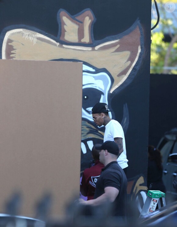 Chris Brown fait des graffitis pour une oeuvre de charité sur un mur à Miami, le 26 mars 2013.