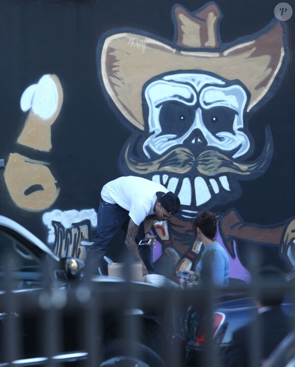Chris Brown fait des graffitis pour une oeuvre de charité sur un mur à Miami, le 26 mars 2013.