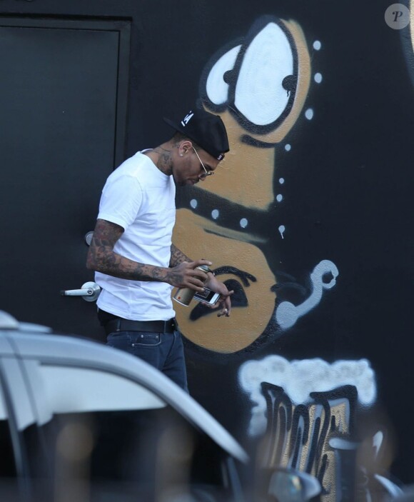 Chris Brown fait des graffitis pour une oeuvre de charité sur un mur à Miami, le 26 mars 2013.