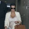Kim Kardashian, enceinte, escortée par la police lors de son arrivée à l'aéroport de Los Angeles, le 13 avril 2013