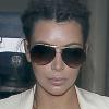 Kim Kardashian, enceinte, affiche une peau terriblement grasse alors qu'elle est escortée par la police lors de son arrivée à l'aéroport de Los Angeles, le 13 avril 2013