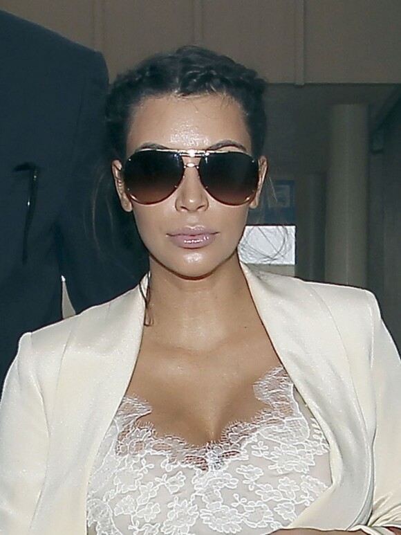 Kim Kardashian, enceinte, escortée par la police lors de son arrivée à l'aéroport de Los Angele, le 13 avril 2013