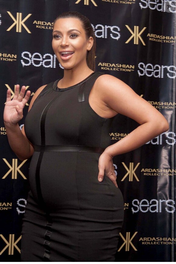Kim Kardashian, enceinte et moulée dans une robe Kardashian Kollection, fête avec ses soeurs Khloé et Kourtney le lancement de leur nouvelle collection au centre commercial Sears. Houston, le 4 mai 2013.
