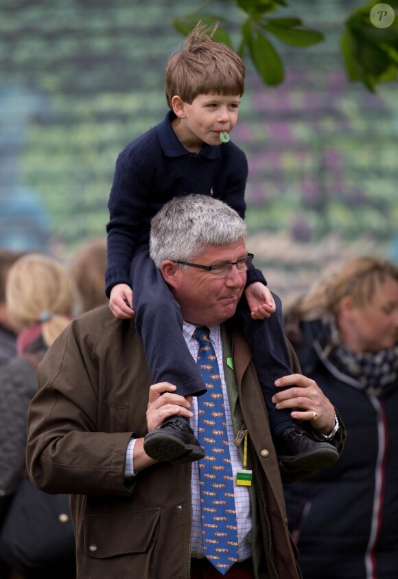 James, vicomte Severn, fils du prince Edward et de la comtesse Sophie de Wessex, sur les épaules d'un garde du corps au Windsor Horse Show le 11 mai 2013
