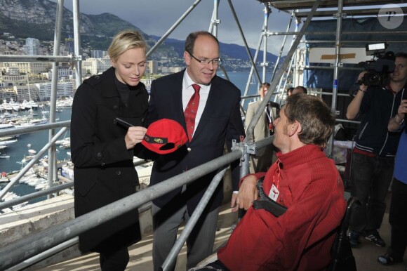 Le prince Albert de Monaco et la princesse Charlene ont signé des autographes lors de leur rencontre avec des handicapés qui assistaient aux essais du Grand Prix de Monaco le 25 mai 2013 à Monaco, gratuitement sur la volonté du couple princier