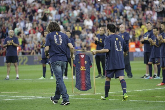 Carles Puyol et Xavi remettent un maillot à Eric Abidal pour son dernier match au Camp Nou le 1er juin 2013.