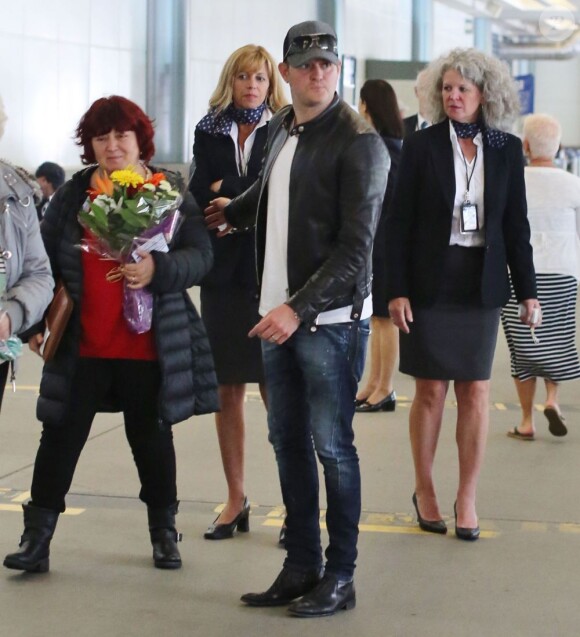 Michael Bublé accueille sa femme Luisana Lopilato, enceinte, avec un bouquet de fleurs à l'aéroport de Vancouver, le 15 juin 2013. Galant, le chanteur lui a apporté des fleurs. Michael Bublé a été vu en train de pousser une poussette... qui transportait leur chien.