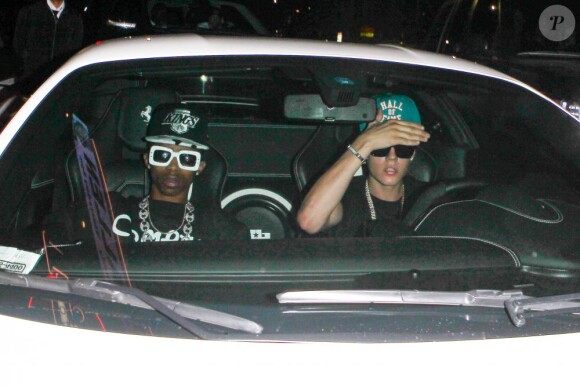 Le chanteur Justin Bieber au volant de sa Ferrari, accompagné de son ami Lil Twist, quitte le club Laugh Factory à Los Angeles, le 17 juin 2013. Il a heurté un photographe mais a été blanchi par la police.