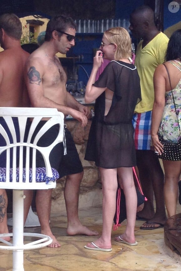 Liam Gallagher sous le soleil d'Ibiza, le 18 juillet 2013. Débarrassé de tout devoir moral et familial, alors qu'il a quitté sa femme, le chanteur semble très intéressé par une femme blonde.