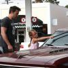Ben Affleck apprend à sa fille Violet, 6 ans, comment laver le pare-brise de leur voiture à Brentwood, le 23 juillet 2013.
