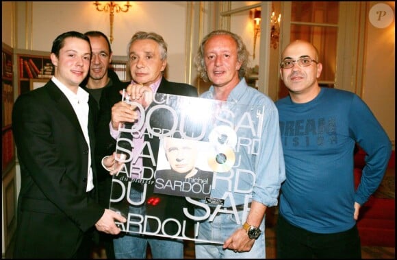 Michel Sardou reçoit un disque de platine pour l'album Du Plaisir, entouré de Didier Barbelivien, Jacques Veneruso, Davy Sardou et Robert Goldman à Paris,le 26 novembre 2004.