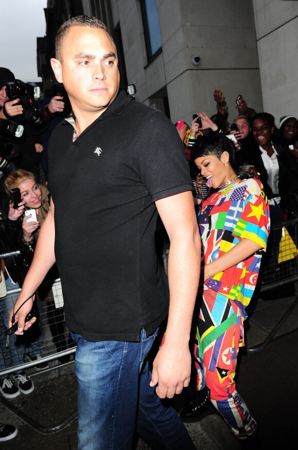 Rihanna, blagueuse en quittant l'hôtel 45 Park Lane, mime un acte sexuel avec son garde du corps. Londres, le 11 septembre 2013.